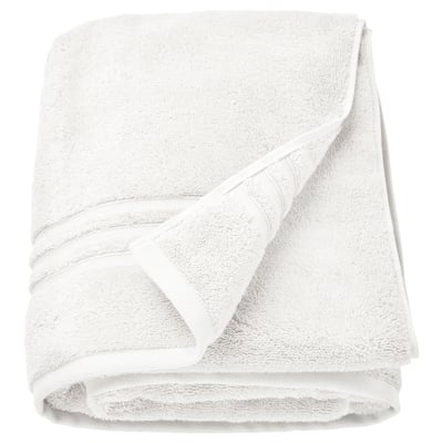 Serviette en coton biologique blanc BROKGLIM, pliée, moelleuse, avec bordure élégante.
