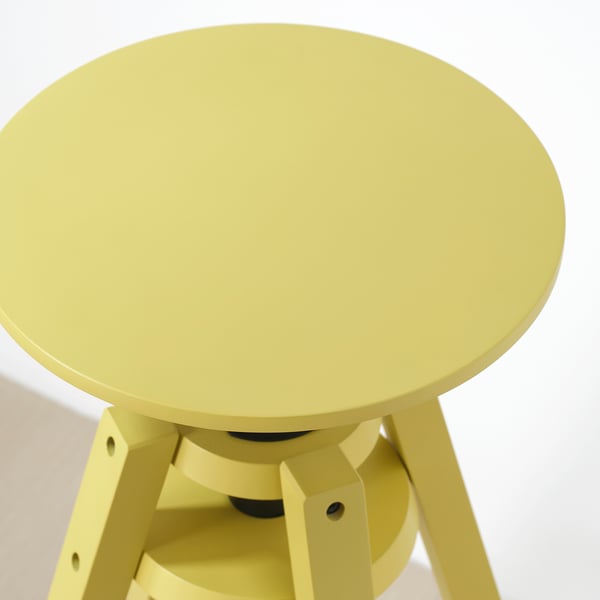 Dessus de table rond jaune vif soutenu par des pieds robustes, probablement réglables, présentant une finition de haute qualité et une construction robuste.