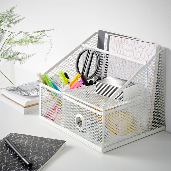 Organisateur de bureau DRÖNJÖNS blanc avec stylos, ciseaux et cahiers ; S’adapte bien sur le bureau avec d’autres fournitures.