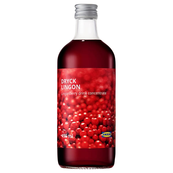 Bouteille de concentré de boisson aux airelles rouges d’ikea. Verre transparent, capuchon argenté, étiquette lumineuse avec des baies.
