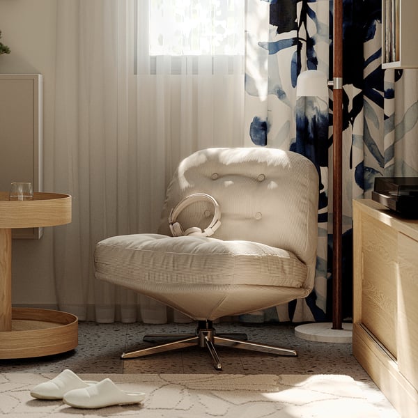 Fauteuil blanc DYVLINGE près de la fenêtre, dossier touffonné, socle en étoile, pièce maîtresse.