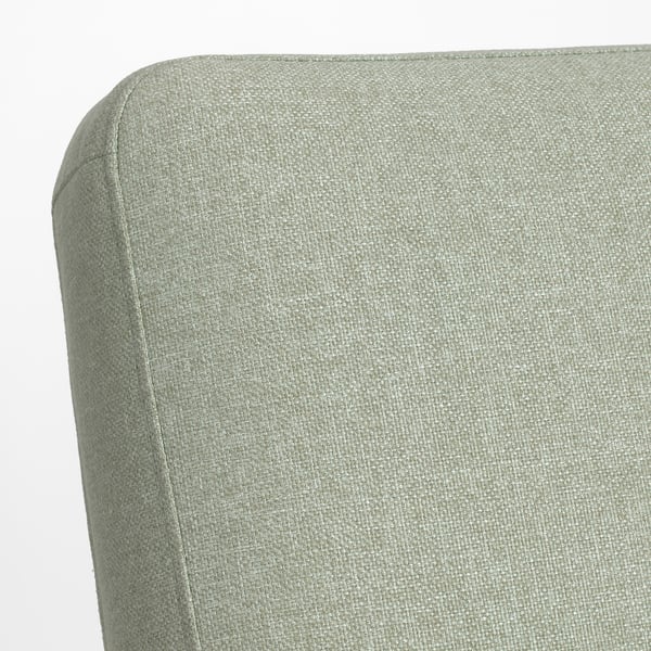 Coin de chaise rembourré vert doux et incurvé, mettant en valeur un rembourrage et des coutures de qualité.