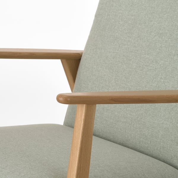 Gros plan d’un fauteuil rétro élégant avec des accoudoirs en bois massif et une assise moelleuse.