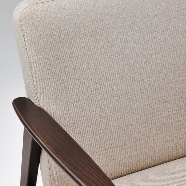 Chaise rembourrée beige avec accoudoirs et pieds en bois foncé, mettant en valeur des matériaux et un savoir-faire de haute qualité.