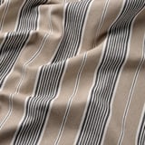 Tissu rayé en gros plan, mettant en valeur une texture et un tissage de qualité. Coton naturel et durable.