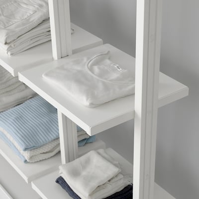 Système de rangement par étagères avec vêtements pliés. Facile à installer et réglable.