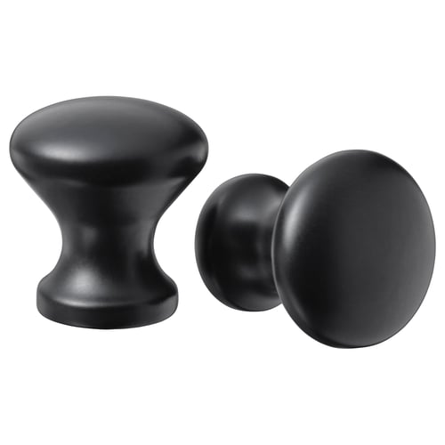 Deux boutons d’armoire noirs ; L’un arrondi, l’autre cylindrique, à la fois élégant et moderne.