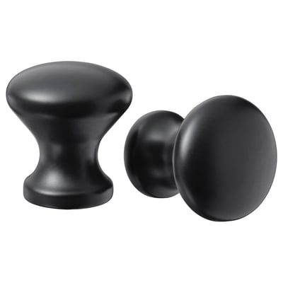 Deux boutons d’armoire noirs ; L’un arrondi, l’autre cylindrique, à la fois élégant et moderne.