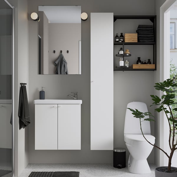 Salle de bain minimaliste : meuble blanc ENHET, lavabo, toilettes, miroir. Accents gris.