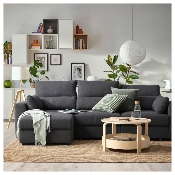 Salon confortable avec canapé ESKILSTUNA gris, table basse en bois, plantes et décoration.