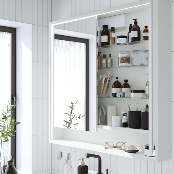 Meuble de toilette blanc moderne avec éclairage intégré, reflétant un intérieur de salle de bains bien rangé.