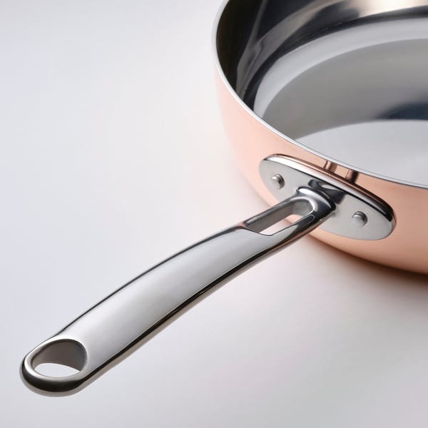 Élégante sauteuse FINMAT avec poignée et couvercle en acier inoxydable. Le corps en cuivre réfléchit la chaleur uniformément. Conception de qualité professionnelle.