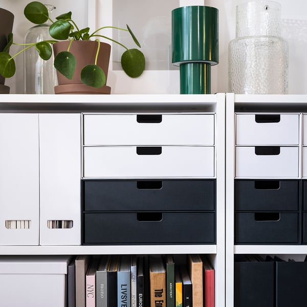 Mini coffres, blancs avec gris, sur des étagères. Parfait pour les bibliothèques ou les bureaux. Complète la décoration.