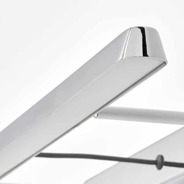 Lampe en chrome poli avec un design élégant et réglable pour un éclairage précis.