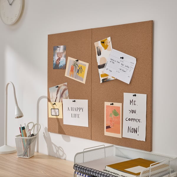 Tableau en liège avec des photos, des notes et des citations sur le mur au-dessus du bureau. Ou un tableau mural en liège avec des photos, des notes et des citations au-dessus du bureau.