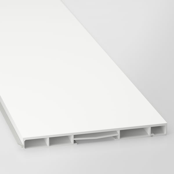 Un gros plan d’un socle d’armoire blanc moderne, montrant une surface élégante et des supports de support.