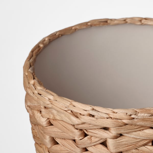 Panier tressé à la main, gros plan. Fabriqué à partir de jacinthe d’eau naturelle, mettant en valeur un tissage complexe et une texture rustique.