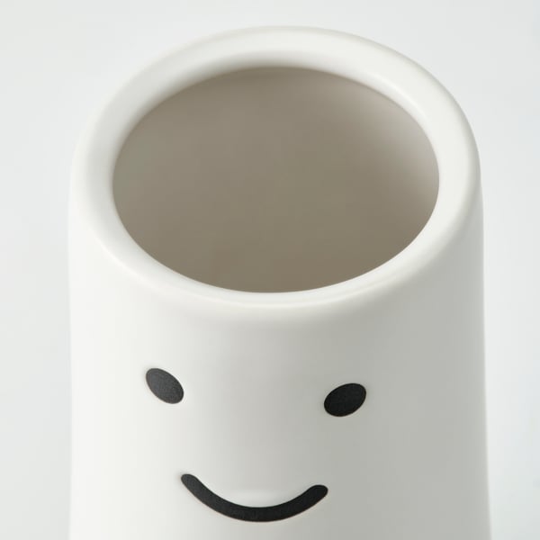 Vase pour visage heureux, blanc avec yeux noirs.