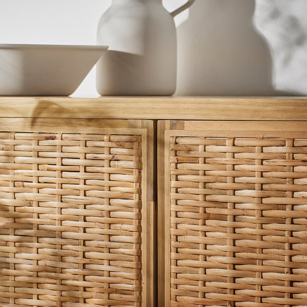Armoire en rotin tressé avec cadre en bois naturel. Détails complexes et pieds réglables. Vase et bol sur le dessus.