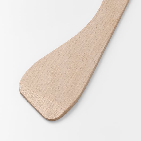 Une spatule en bois lisse et de couleur claire repose sur un fond uni, mettant en valeur sa surface propre et polie et son savoir-faire robuste.