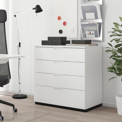 Classeur GALANT blanc à 4 tiroirs dans un bureau minimaliste, avec lampe, boîtes et plante.