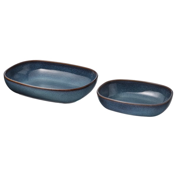 Deux plats à four en grès bleu, de forme ovale avec un bord doré, sont assis côte à côte.