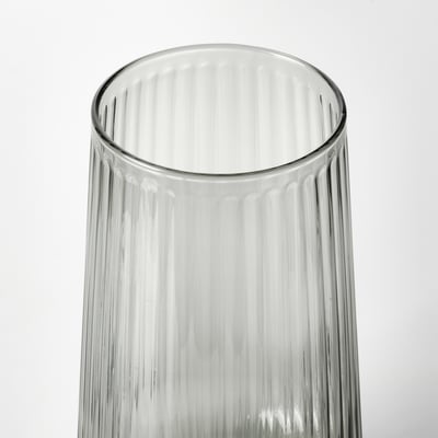 Vase en verre transparent à texture nervurée, debout sur fond blanc.