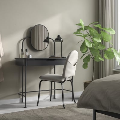 Coiffeuse GRÅFJÄLLET noire avec miroir, à côté de la plante et de la chaise, minimaliste.