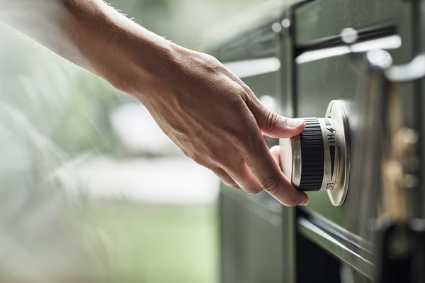 Personne ajustant un gril à gaz extérieur vert avec des commandes en acier inoxydable.