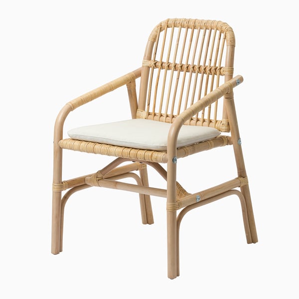 Une chaise en rotin avec une assise rembourrée, offrant confort et nettoyage facile avec une housse lavable.