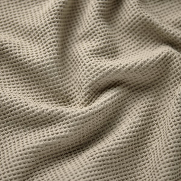 En gros plan léger et texturé, mettant en valeur un tissage complexe et une qualité de tissu doux.