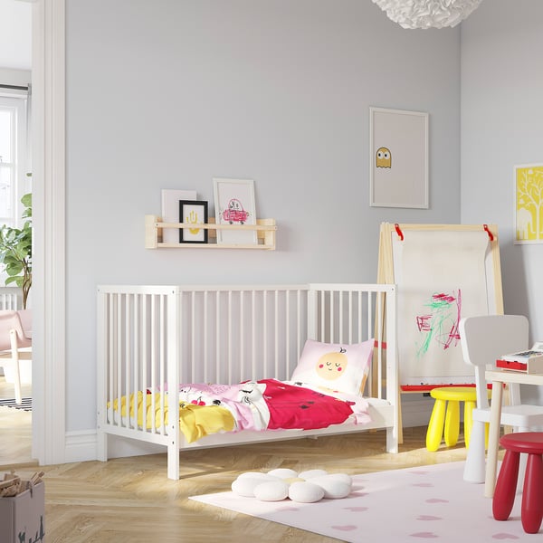 Chambre d’enfant avec lit bébé GULLIVER, literie colorée, chevalet d’art pour enfants et tapis.