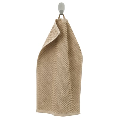 Serviette en coton GULVIAL beige suspendue. Texture douce et éponge, forme rectangulaire, design simple.