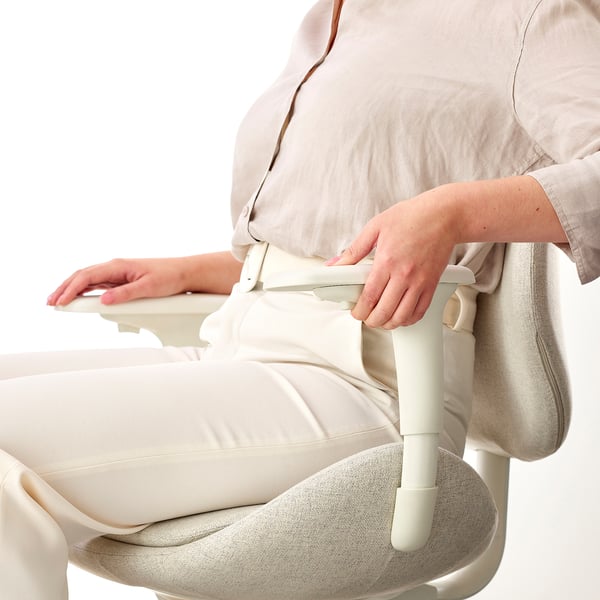 Femme ajustant les accoudoirs ergonomiques de la chaise de bureau ; Démonstration de la fonction réglable en hauteur et en largeur.