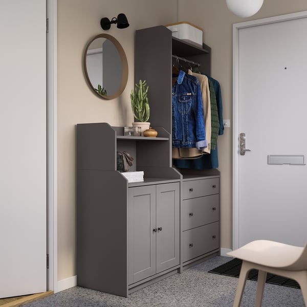 Entrée organisée avec des meubles HAUGA gris, un miroir et des plantes.