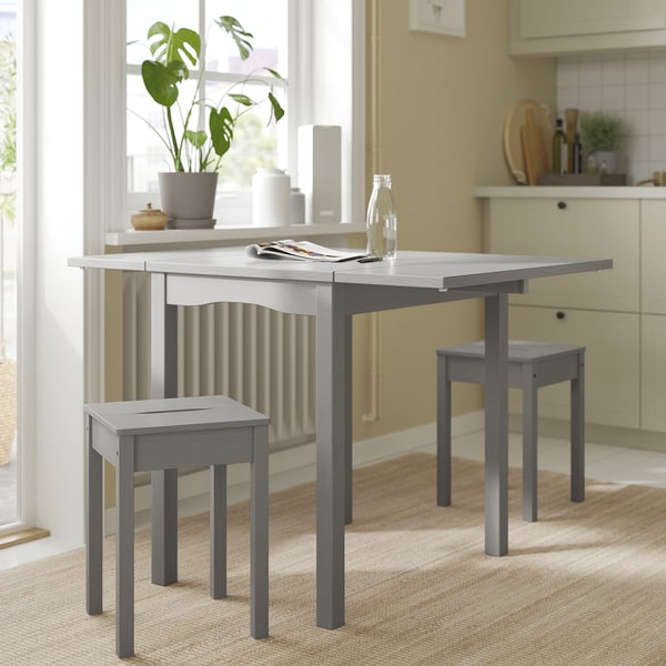 Elégante table à abattants gris HAUGA avec tabourets. Parfait pour les petits espaces, s’étend jusqu’à 4 places. Design moderne avec placage de bois et pin massif.