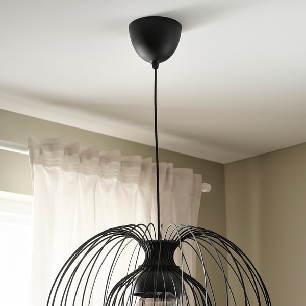 Une suspension moderne au design complexe et tissé est suspendue au plafond, offrant un éclairage réglable.