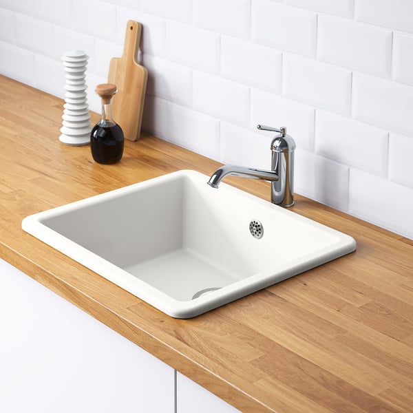 Évier HAVSEN blanc avec robinet argenté sur comptoir en bois, y compris piège à eau et passoire.