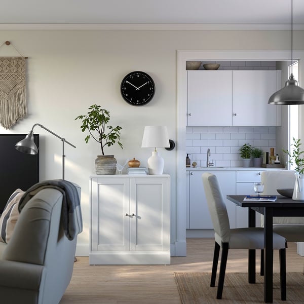 Maison moderne à aire ouverte avec armoire HAVSTA blanche, chaise grise, plante, lampe, horloge et salle à manger.