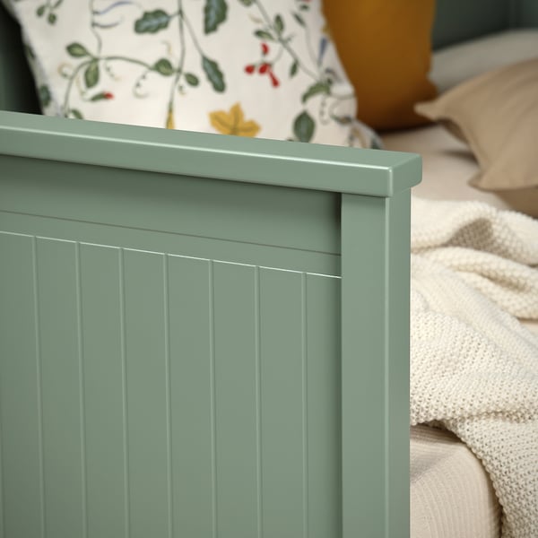 Méridienne en bois vert sauge avec rainures verticales pour un canapé élégant et douillet et un espace de sommeil supplémentaire.