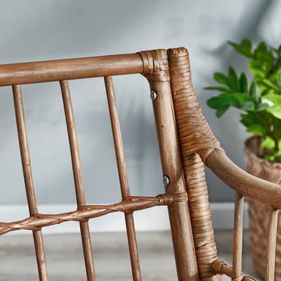 Détail du fauteuil en rotin tissé à la main, matériaux naturels, design complexe, lignes douces