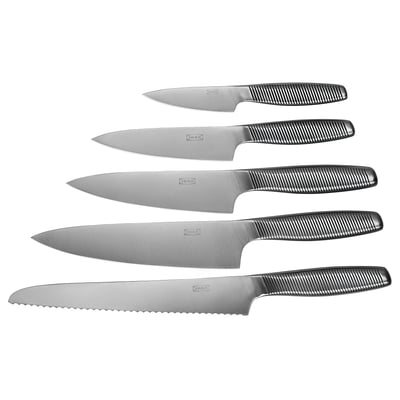 Six couteaux IKEA 365+, en acier inoxydable avec des poignées rainurées noires, disposés soigneusement en rangée, adaptés à diverses tâches de cuisine.