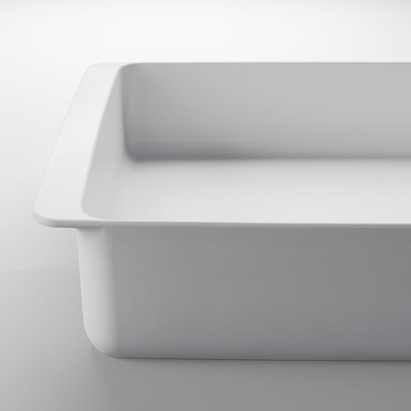 Plat de cuisson en porcelaine blanche, rectangulaire, surface lisse, poignées solides, propre.