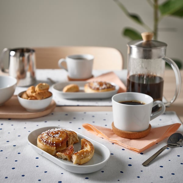 Petit-déjeuner avec assiette, viennoiseries, café et bols.