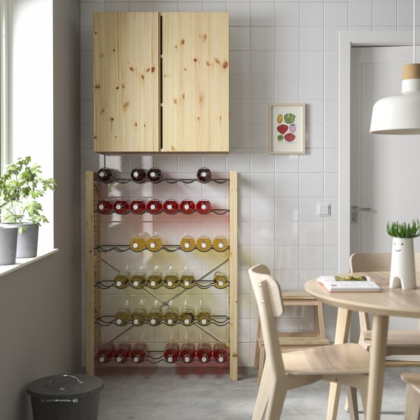 Cuisine moderne avec rangement en pin IVAR, casiers à vin, table à manger et lumière naturelle.