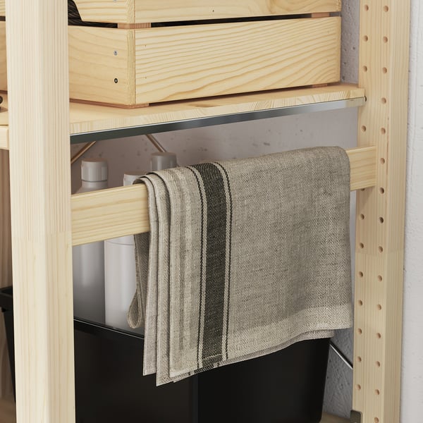 Étagère en bois avec étagères mobiles ; un tissu gris pend de l’un d’eux.
