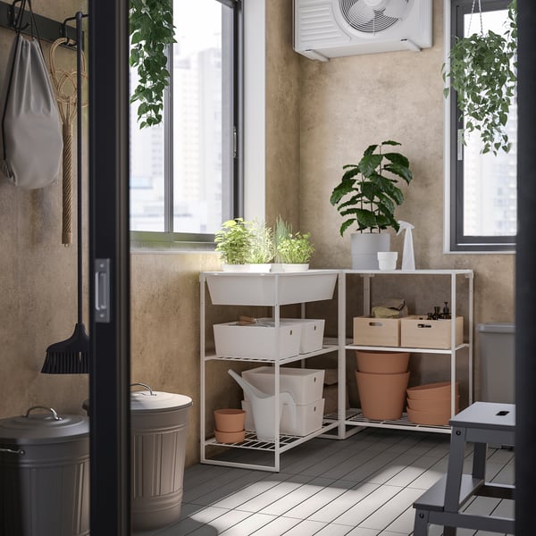 Balcon moderne avec rangements blancs JOSTEIN, plantes et outils de nettoyage.
