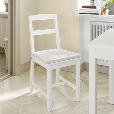 Chaise en bois blanc avec coussin, design simple et confortable.