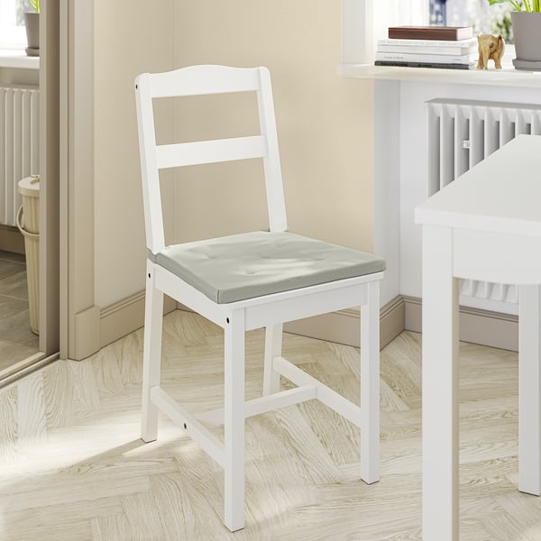 Chaise en bois blanc avec siège rembourré gris, design simple, placée dans une pièce confortable.