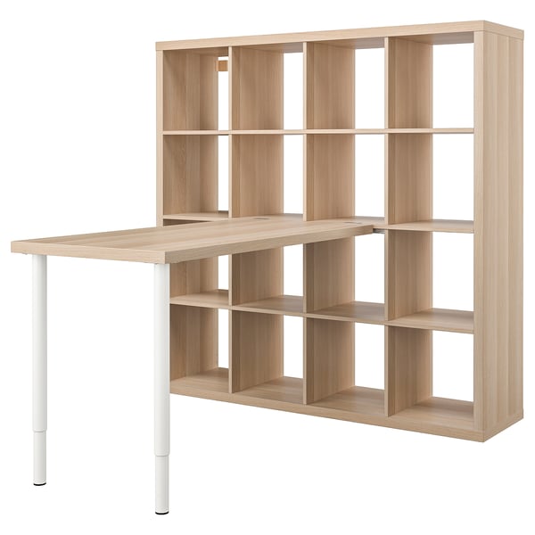 Une étagère KALLAX en bois clair avec un bureau intégré, doté de plusieurs cubes ouverts pour le rangement.